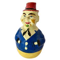 a blue and yellow vase with a clown's face painted on the front side