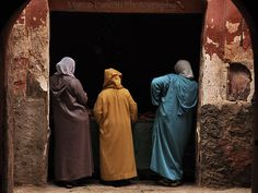 three women standing in the doorway of an old building