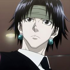 an anime character with black hair and green earrings on his head, staring at the camera