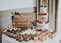 a wedding cake and cupcakes on a table