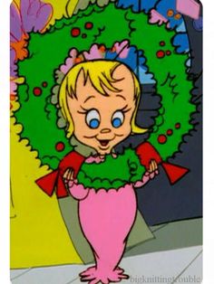 an image of a cartoon character holding a wreath in front of her face and looking at the camera