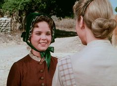 two women standing next to each other talking