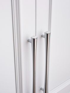 two metal poles are standing next to each other in front of a door with white trim