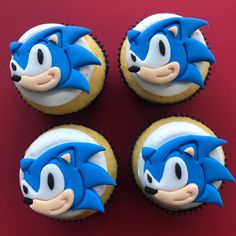 three cupcakes with blue frosting and sonic the hedgehog faces on them