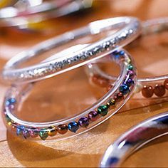 two silver rings with beads are sitting on a table