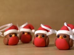 five little birds with santa hats on their heads are lined up against a brown background