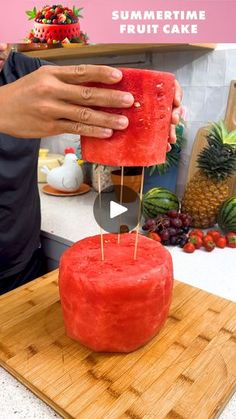 someone is decorating a fruit cake on a cutting board