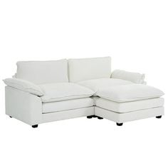 a white sectional couch with pillows on it