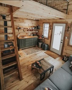 a living room filled with furniture next to a kitchen and dining area in a log cabin