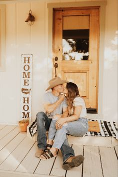 a man and woman sitting on the porch kissing