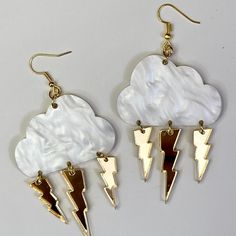 "Let every day be a rainy and stormy day with these storm cloud dangle earrings. Choose from white cloud, pink clouds, sparkle clouds, or smoke grey clouds. Silver, gold, or translucent lightning bolts. Drop length 3.5\" Length 2.34\" width 1.34 Jump rings and ear wires are nickel free." Cloud Clothes, Cloud Fashion, Cloud Jewelry, Cloud Rain, Cloud Earrings, Cloud Pink, Lighting Bolt, Lightning Bolts, Grey Clouds