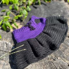 two knitted gloves sitting on top of a wooden table