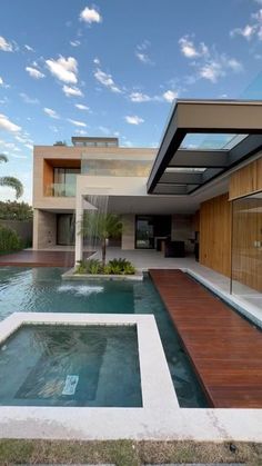 an outdoor swimming pool in front of a modern house