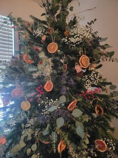 a christmas tree decorated with oranges and berries