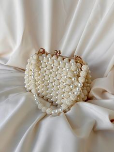 🌟 Elevate your style with this exquisitely crafted handbag adorned with pearl details. 🌟 Handcrafted with care, this bag is designed to add a touch of sophistication to every moment. The elegance of the pearl embellishments sets this bag apart, transforming it into a unique accessory. 🌸 Why Choose This Bag? 🌸 More than just an accessory, this bag is an opportunity to reflect your style and grace. Whether for a special event or to enhance your daily chic, this pearl-adorned bag complements ev Cream Evening Bag With Pearl Handle, Pearl Evening Bag With Pearl Handle For Wedding Guest, Beige Clutch Evening Bag With Pearl Handle, Beige Rectangular Evening Bag With Pearl Handle, Beige Pouch Clutch With Pearl Handle, Beige Rectangular Evening Bag With Pearl Embroidery, Cream Bags With Pearl Embroidery For Events, Beige Pearl Evening Bag For Events, Beige Handheld Evening Bag With Pearl Handle