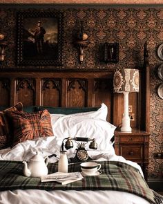 an old fashioned phone is sitting on the bed in this bedroom with plaid sheets and pillows