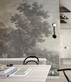 a dining room with a table and chairs in front of a wallpapered mural