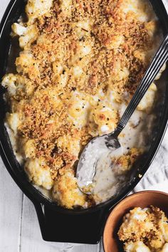 a casserole dish filled with macaroni and cheese next to a bowl of sour cream