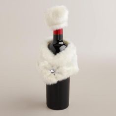 a wine bottle that has been decorated with fur and is sitting in a black vase