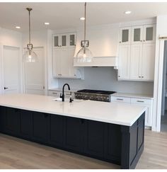 a kitchen with white cabinets and black island