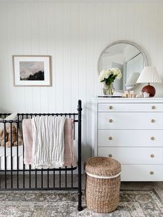 a baby crib and dresser in a white room