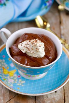 a cup filled with chocolate pudding on top of a blue plate