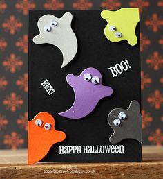 a halloween card with three ghost faces on it