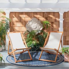 two lawn chairs sitting on top of a blue and white rug next to a brick wall