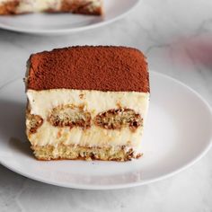 a piece of cake sitting on top of a white plate next to another slice of cake