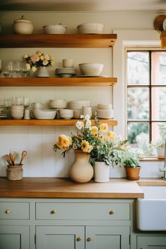 the kitchen counter is full of dishes and flowers