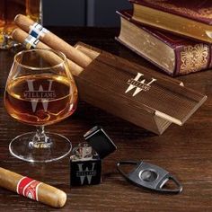 an assortment of liquor and cigars on a wooden table next to two lighters