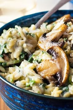 a blue bowl filled with pasta and mushrooms