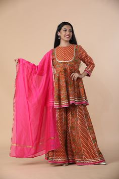 This stunning Mustard Peplum Sharara Set With Gotta Patti¬† Work is perfect for any event. The set comes with 3 pieces that is mustard flared printed short kurta with beautiful lace work, closed neck, 3/4th sleeves teamed with printed flared sharara and a pink dupatta to match.Fabric: Rayon CottonWashing instructions: Dry CleanModel is wearing size Small Anarkali Palazzo Set With Kalamkari Print, Fitted Kalamkari Print Palazzo Set For Diwali, Sharara With Kalamkari Print For Festivals, Diwali Sharara With Kalamkari Print And Straight Kurta, Kalamkari Print Sharara For Festivals, Fitted Kalamkari Print Palazzo Set For Festive Occasions, Long Sleeve Block Print Sharara For Navratri, Orange Anarkali Set With Printed Motifs, Festive Kalamkari Print Fitted Palazzo Set