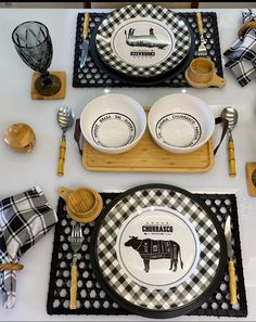 the table is set with black and white plates, utensils, and napkins