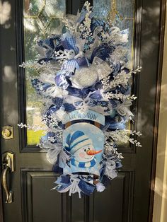 the front door is decorated with blue and white ribbons, snowflakes, and frosting