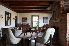 a living room filled with furniture next to a fire place in a brick wall building