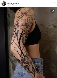 a woman's arm with flowers and vines on the arm, in black ink