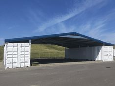 a large white container sitting in the middle of a parking lot next to a field