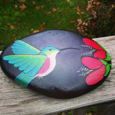 a painted rock sitting on top of a wooden bench