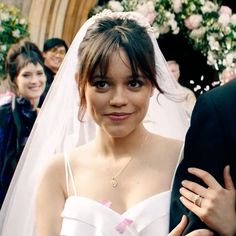 a woman in a wedding dress standing next to a man