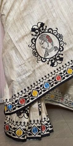 an embroidered white sari with multicolored designs on the border and black border