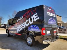 the back of a black truck parked in front of a building with an emergency rescue sticker on it