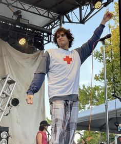 a man standing on top of a stage with his arms in the air