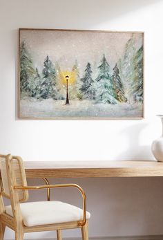 a painting hanging on the wall above a desk with a chair and table in front of it