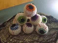 six crocheted balls sitting on top of a black doily covered tablecloth