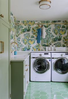 a washer and dryer in a small room with wallpaper on the walls