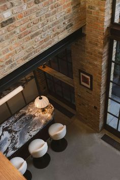 an overhead view of a living room with brick walls and floor to ceiling glass doors