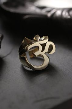 Cool Ohm Sign Ring (version two) original made and designed by Defy Own unique design of Ohm, spiritual meaning of the sacred sound. This version shows detail of the ohm sign in three dimensional. -The ring size is between 7 - 10 US. **Please choose options below.** - The ring dimensions are ; approx. 2.5 x 2.5 x 2.5 cm. **Shipping to World Wide** - Please allow us to prepare the item and parcel between 3-5 working days. For Brass / Silver plated / Gold plated (*Between 5-7 working days For Ster Nickel-free Spiritual Jewelry For Promise, Symbolic Adjustable Ring With Unique Design, Spiritual Brass Jewelry With Polished Finish, Symbolic Brass Promise Rings, Symbolic Rings With Unique Design For Gift, Spiritual Ceremonial Rings With Polished Finish, Adjustable Spiritual Rings, Symbolic Brass Jewelry For Promise, Symbolic Polished Brass Ring