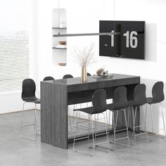 a dining room table with chairs and a clock on the wall above it that reads 16