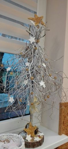 a white christmas tree sitting on top of a table next to a window sill